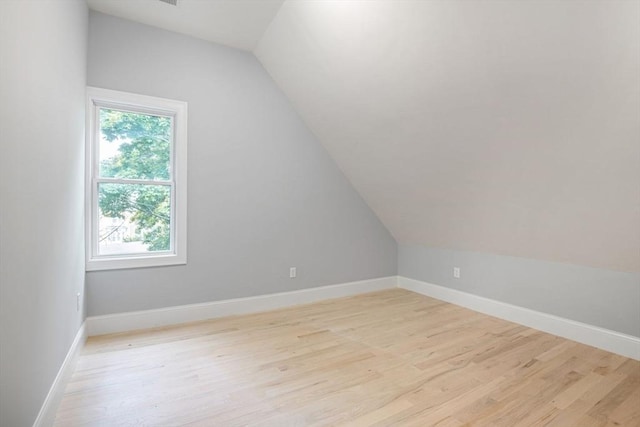 bonus room with vaulted ceiling and light hardwood / wood-style flooring