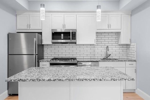 kitchen with white cabinetry, sink, stainless steel appliances, and light stone countertops