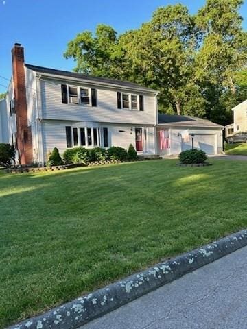 colonial house featuring a front yard and a chimney