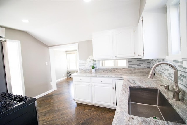 kitchen featuring a sink, backsplash, dark wood-type flooring, black range with gas stovetop, and white cabinets