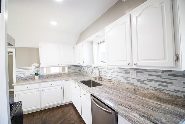 kitchen featuring dishwasher, a sink, decorative backsplash, vaulted ceiling, and light stone counters