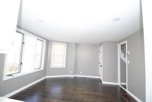 unfurnished room featuring dark wood-style floors and baseboards
