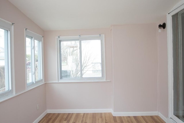 empty room featuring light wood finished floors and baseboards