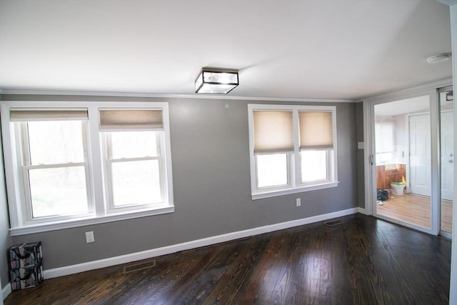 unfurnished room featuring baseboards, dark wood-type flooring, a smoke detector, and ornamental molding