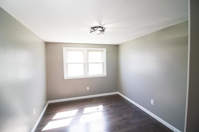 unfurnished room with dark wood-style floors and baseboards