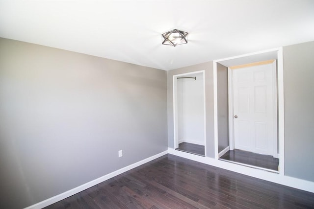 empty room featuring dark wood finished floors and baseboards