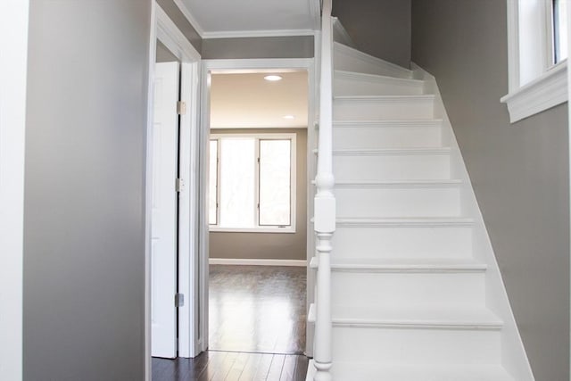 staircase featuring wood finished floors and baseboards