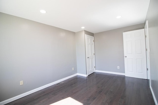 spare room featuring dark wood finished floors, baseboards, and recessed lighting