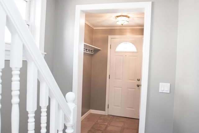 foyer entrance featuring baseboards and crown molding