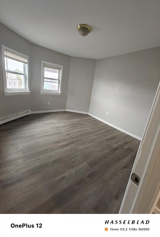 54 Shirley Ave, Revere, MA 02151 - spare room with a baseboard radiator, dark wood finished floors, and baseboards