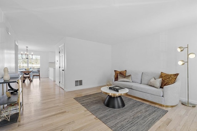 living room featuring an inviting chandelier and light hardwood / wood-style floors