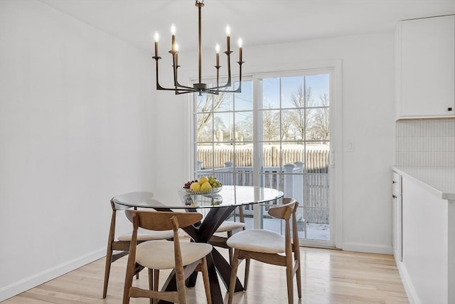 dining area featuring a notable chandelier and light wood-type flooring