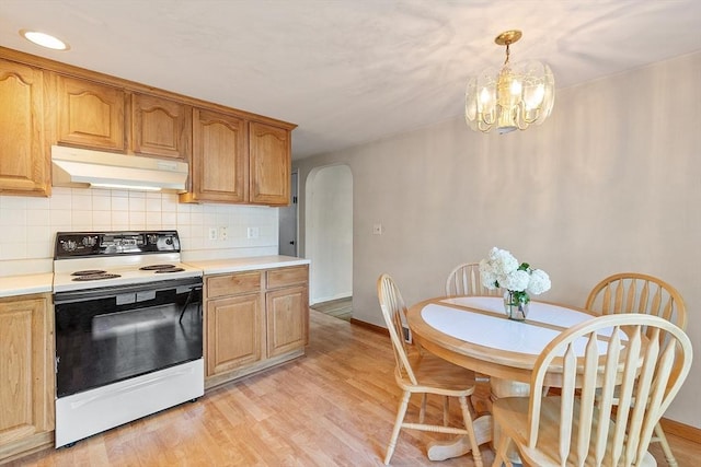 15 Moore Rd, Westford, MA 01886 - kitchen with under cabinet range hood, range with electric stovetop, arched walkways, tasteful backsplash, and light countertops