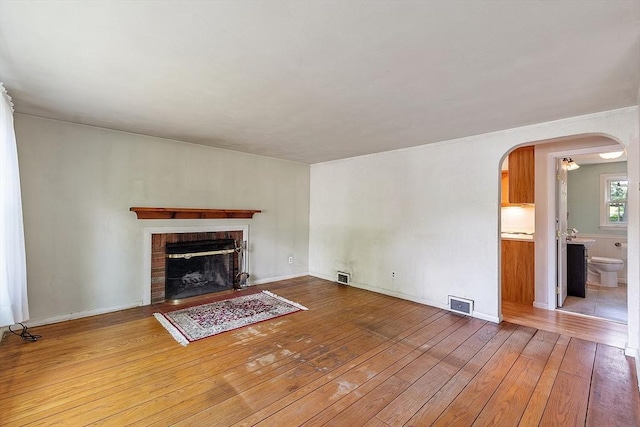 15 Moore Rd, Westford, MA 01886 - unfurnished living room featuring wood-type flooring, arched walkways, and a fireplace