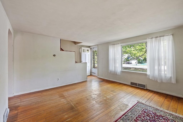 15 Moore Rd, Westford, MA 01886 - unfurnished room featuring hardwood / wood-style floors, baseboards, arched walkways, and stairway