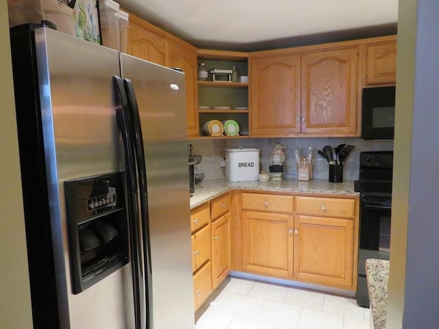 155 Kendrick Ave Unit 306, Quincy, MA 02169 - kitchen featuring stainless steel fridge with ice dispenser, black microwave, range, light stone counters, and decorative backsplash