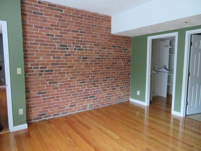 155 Kendrick Ave Unit 306, Quincy, MA 02169 - empty room with light wood finished floors, baseboards, and brick wall
