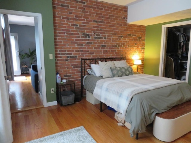 155 Kendrick Ave Unit 306, Quincy, MA 02169 - bedroom featuring light wood-style floors, a closet, and brick wall