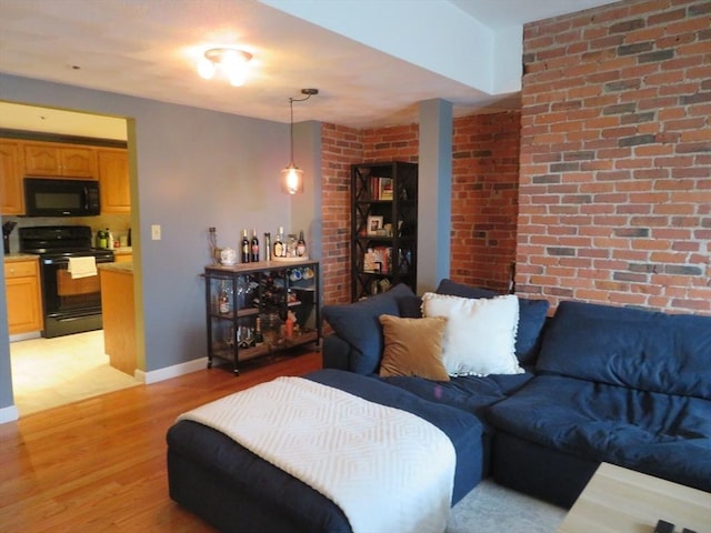 155 Kendrick Ave Unit 306, Quincy, MA 02169 - living area with light wood-style floors, brick wall, a dry bar, and baseboards