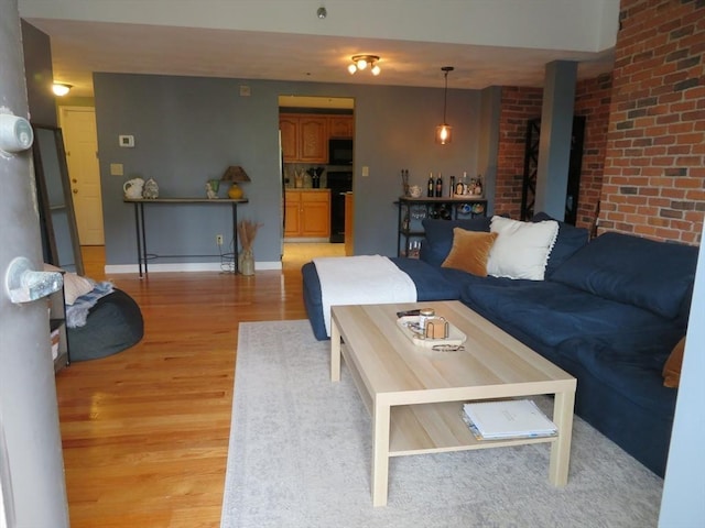 155 Kendrick Ave Unit 306, Quincy, MA 02169 - living area with light wood-style floors, brick wall, and baseboards