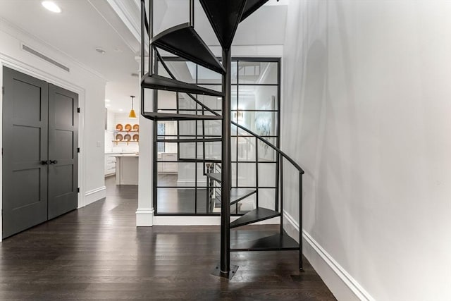 stairs featuring crown molding and wood-type flooring