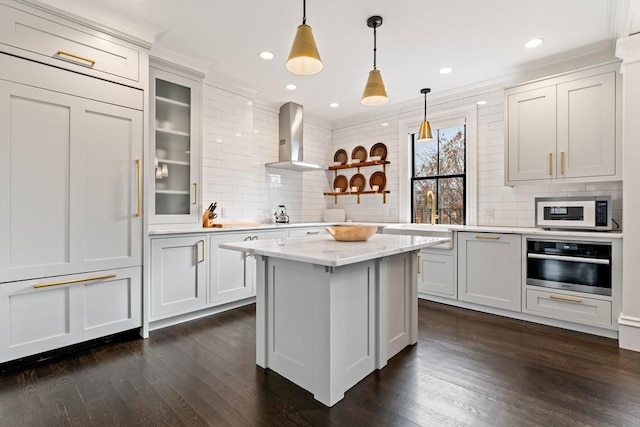 kitchen featuring white cabinetry, stainless steel oven, and wall chimney range hood