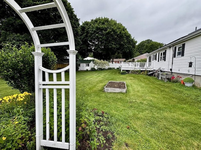 43 Shirley Ave, Methuen, MA 01844 - view of grassy yard with a vegetable garden and a wooden deck