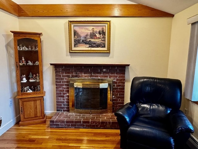 43 Shirley Ave, Methuen, MA 01844 - living area with wood finished floors, a brick fireplace, vaulted ceiling, and a baseboard radiator