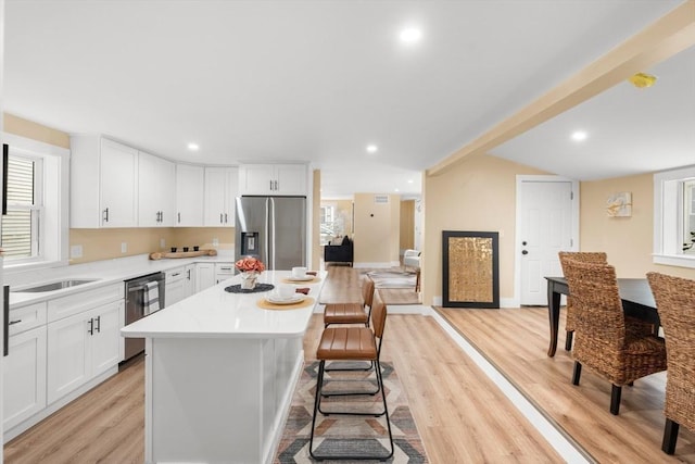 29 Beaver St, Salem, MA 01970 - kitchen featuring stainless steel appliances, light wood-style flooring, a center island, light countertops, and white cabinets