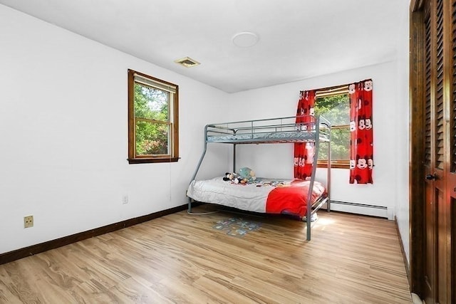 163 Walnut Rd, Wrentham, MA 02093 - bedroom featuring wood finished floors, multiple windows, baseboards, and a baseboard heating unit