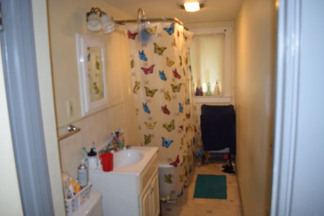 bathroom featuring decorative backsplash, a shower with curtain, vanity, and toilet