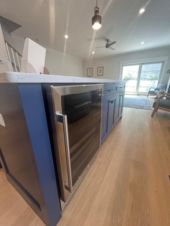 255 Old Main Rd Unit 2A, Falmouth, MA 02556 - kitchen with beverage cooler, light wood finished floors, ceiling fan, light countertops, and pendant lighting