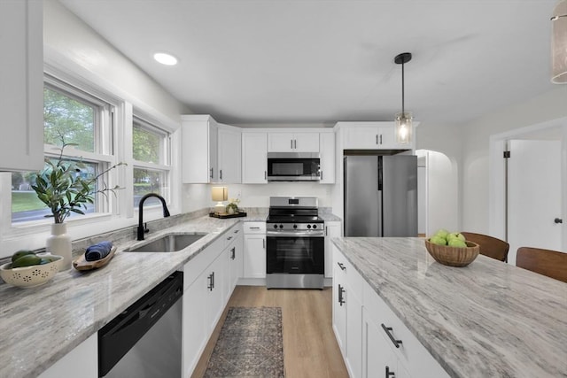 195 Pompeo Rd, Thompson, CT 06255 - kitchen with stainless steel appliances, light stone countertops, decorative light fixtures, light wood finished floors, and white cabinets