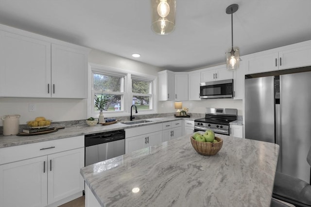 195 Pompeo Rd, Thompson, CT 06255 - kitchen with stainless steel appliances, light stone counters, white cabinetry, and pendant lighting