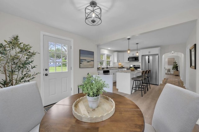 195 Pompeo Rd, Thompson, CT 06255 - dining area with arched walkways, healthy amount of natural light, and light wood-style floors