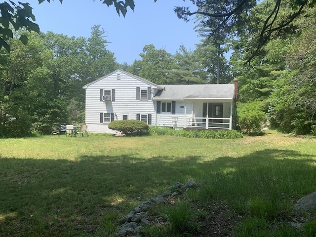 back of property featuring a chimney and a lawn