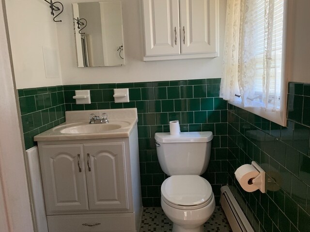 bathroom with tile patterned floors, vanity, toilet, and tile walls