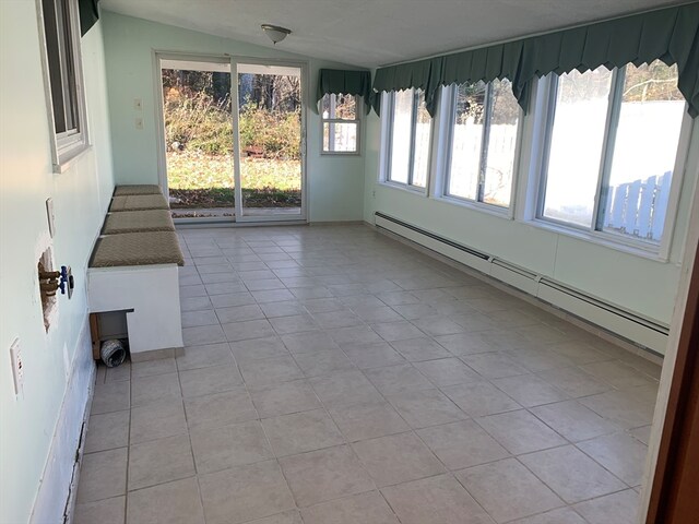 unfurnished sunroom with plenty of natural light, vaulted ceiling, and a baseboard heating unit