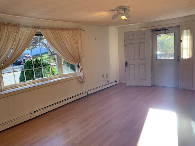 foyer with hardwood / wood-style floors and baseboard heating