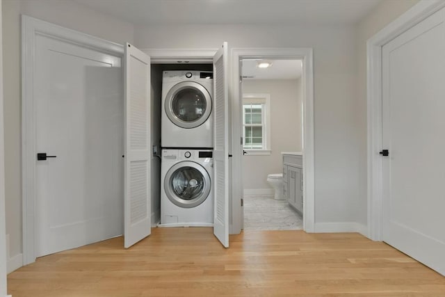 176 Medford St Unit 176, Arlington, MA 02474 - laundry room featuring stacked washing machine and dryer and light wood-style floors