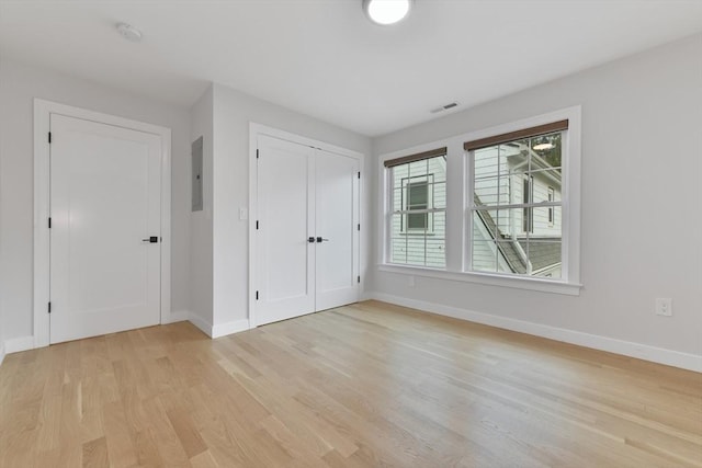 176 Medford St Unit 176, Arlington, MA 02474 - unfurnished bedroom featuring light wood-style flooring, electric panel, and a closet