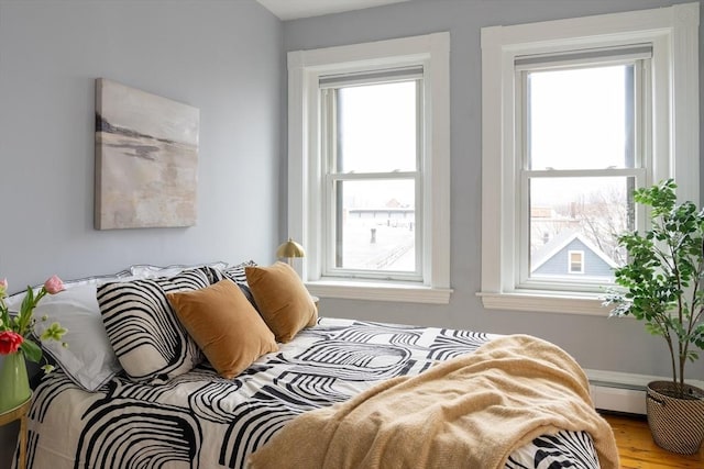 bedroom featuring baseboard heating and wood finished floors