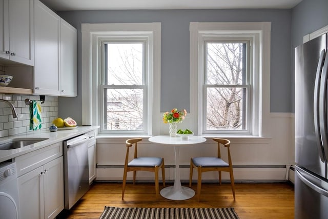 kitchen with washer / clothes dryer, a healthy amount of sunlight, appliances with stainless steel finishes, and a sink