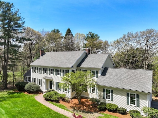 22 Forest Hill Rd, Wayland, MA 01778 - colonial house featuring a chimney, a front yard, and a shingled roof