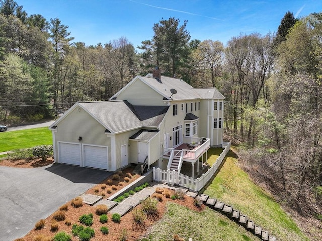 22 Forest Hill Rd, Wayland, MA 01778 - view of front of house featuring asphalt driveway, a shingled roof, a chimney, a deck, and a front yard