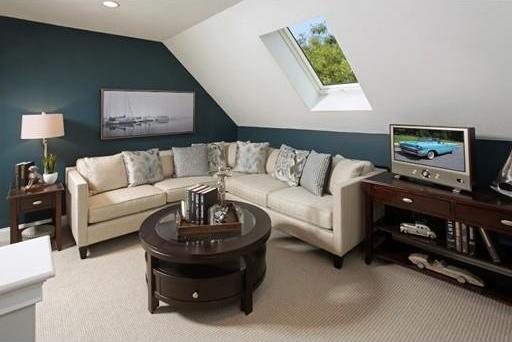 living room with lofted ceiling with skylight and light carpet