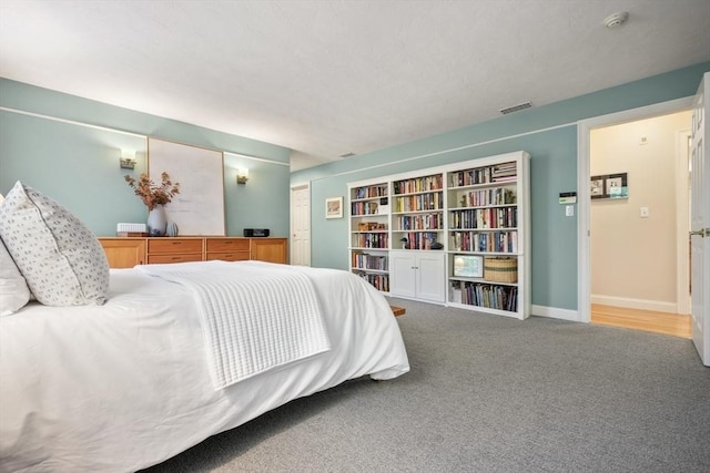 carpeted bedroom featuring baseboards and visible vents