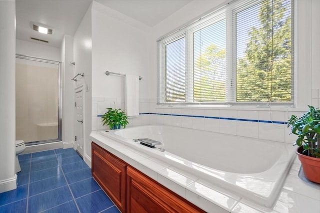 full bathroom featuring a stall shower, a bath, visible vents, and tile patterned floors