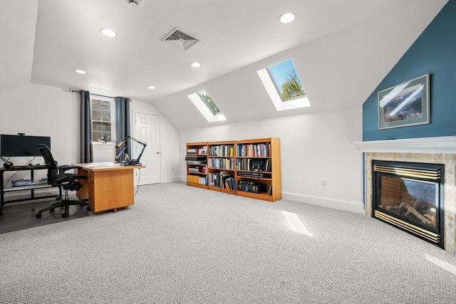 home office with carpet flooring, vaulted ceiling with skylight, visible vents, baseboards, and recessed lighting