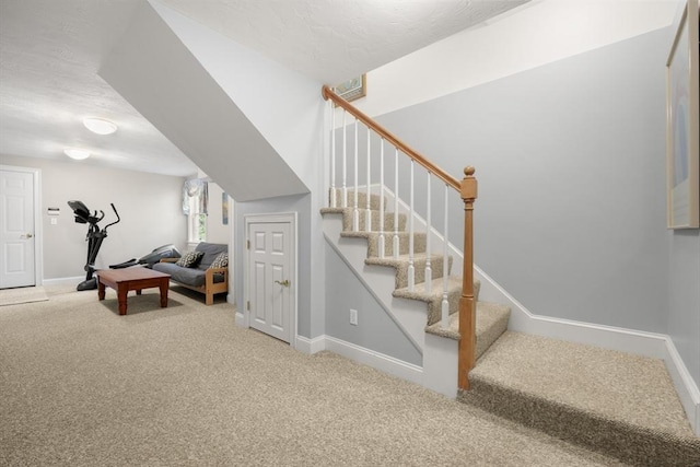 staircase featuring carpet floors and baseboards